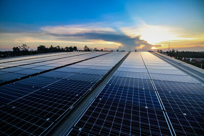 Solarfelder auf einem Industriedach bei Sonnenaufgang