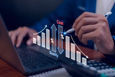 Mann mit Stift sitzt vor Laptop mit Tabelle